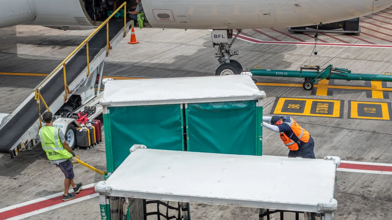 Equipe de solo trabalhando junto a um avião no aeroporto
