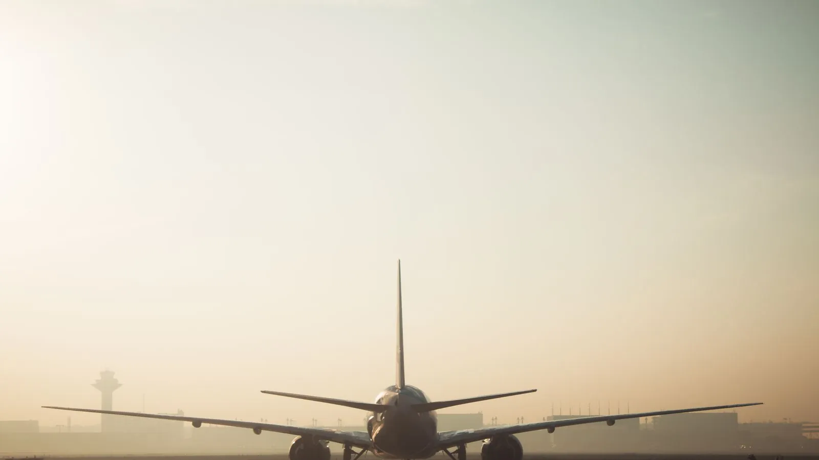 Avião na pista numa manhã de neblina